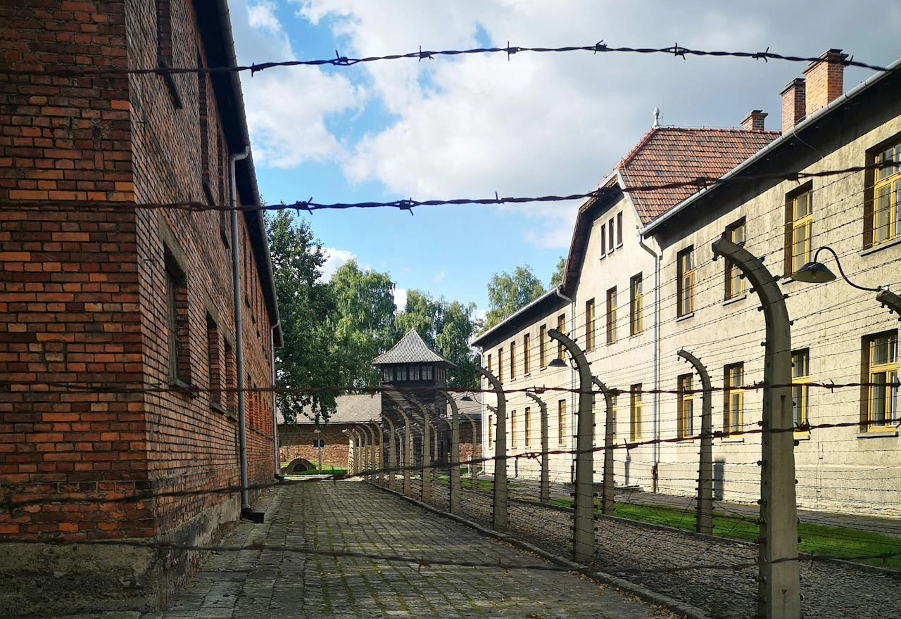A photo displaying distant buildings bordered by barbed wired
